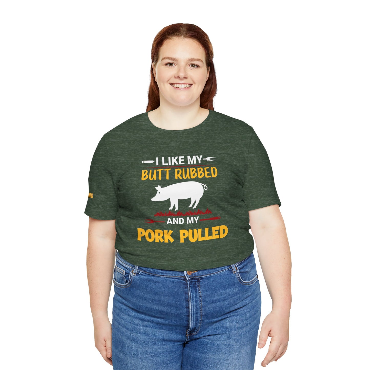 BBQ-themed t-shirt design featuring the phrase "I Like My Butt Rubbed & My Pork Pulled" with a pig silhouette, grill forks, and fire accents. Available in plus sizes.
