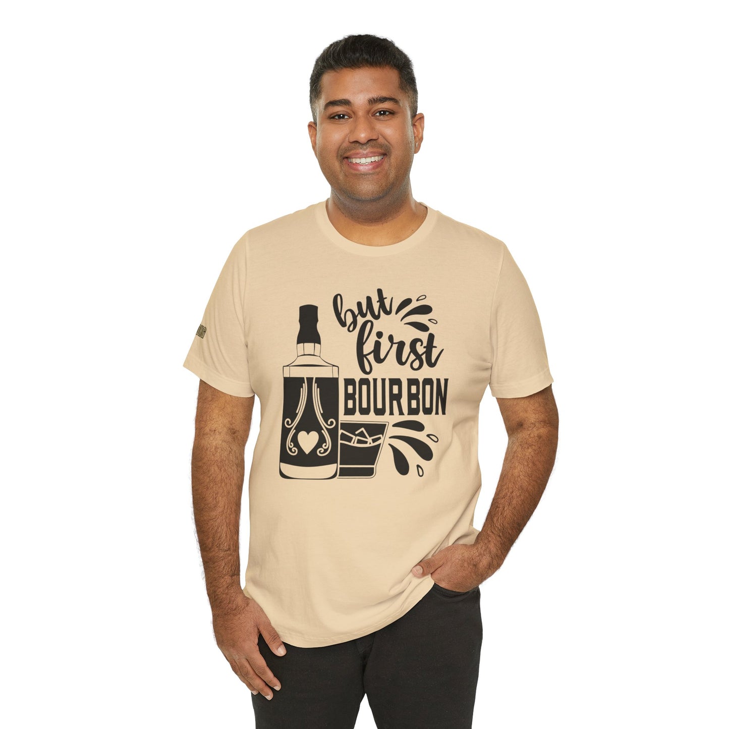 A bourbon-themed design featuring a whiskey bottle, rocks glass, and the phrase "But First, Bourbon" in stylish lettering. Available in many colors and plus sizes.