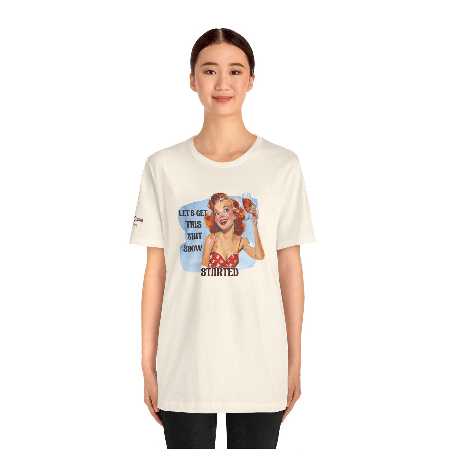 Vintage pin-up woman with bright red hair, holding a glass of wine with a manic smile. The phrase reads: "Let’s Get This Sh*t Show Started."