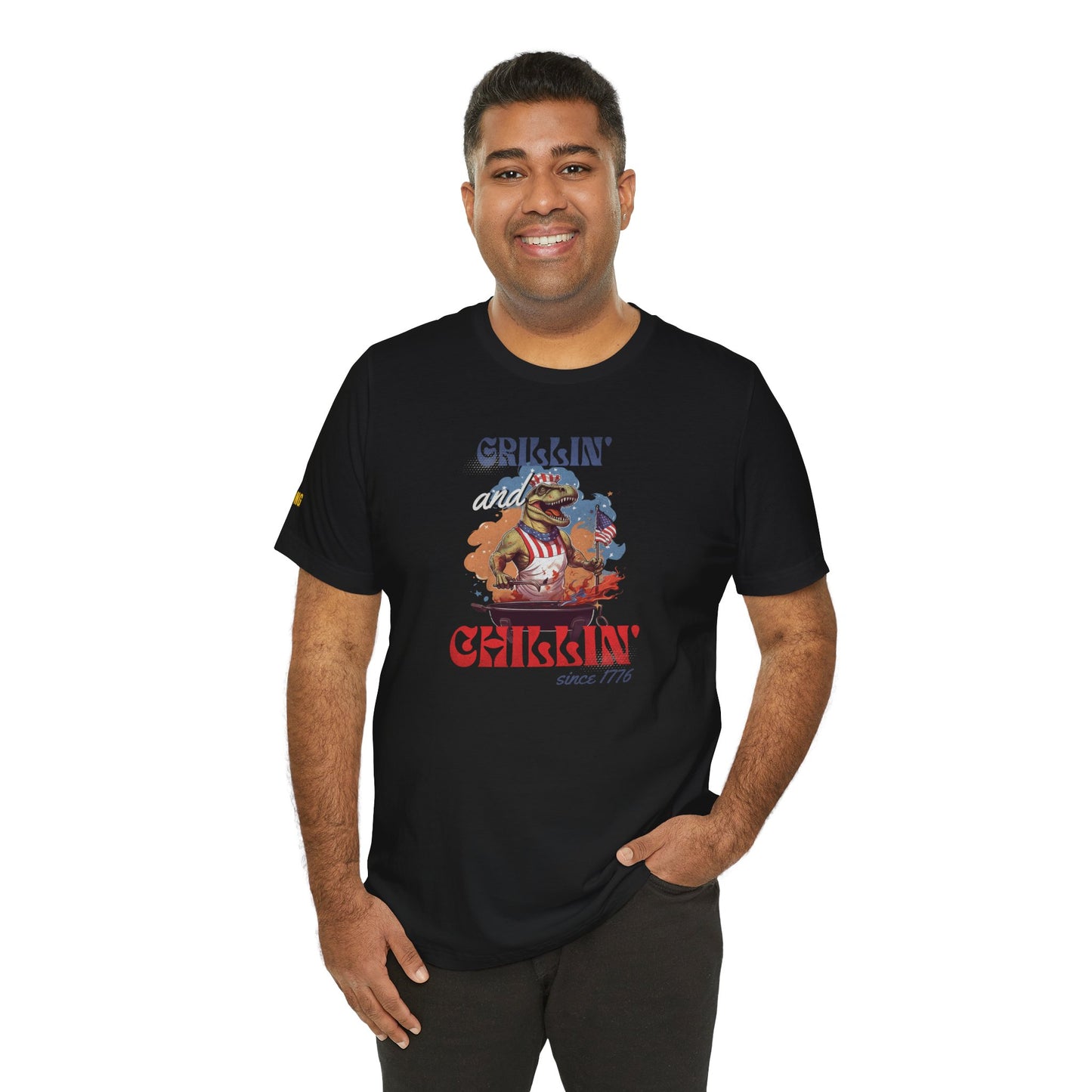 Funny 4th of July BBQ t-shirt featuring a patriotic T-Rex grilling in a red, white, and blue apron, waving an American flag. Perfect for beer and BBQ lovers. in Black.