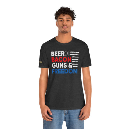 Funny quote Beer Bacon Guns & Freedom T-Shirt with bold red, white & blue American flag design – perfect for patriots and beer lovers. In dark heather grey.