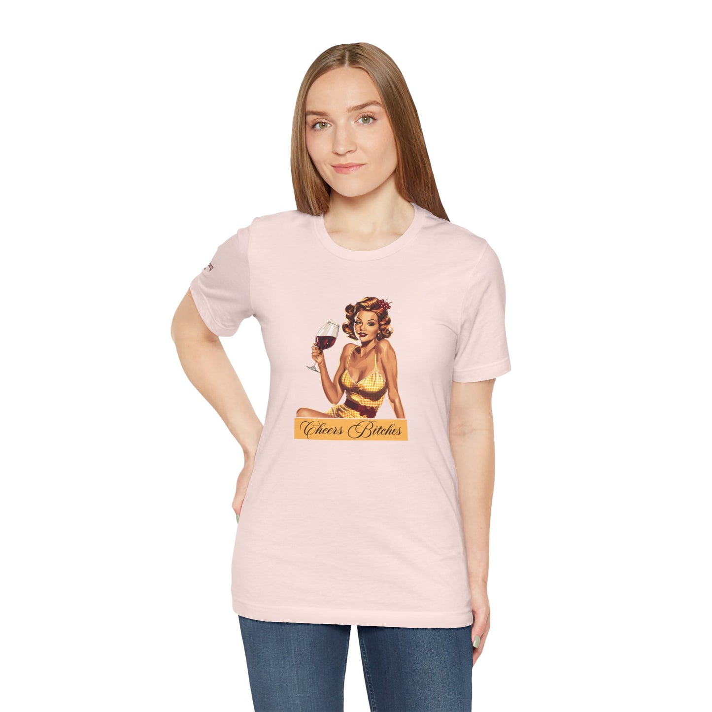 Retro pin-up girl in a yellow gingham dress holding a glass of red wine, with the phrase "Cheers Bitches" in an elegant script banner.
