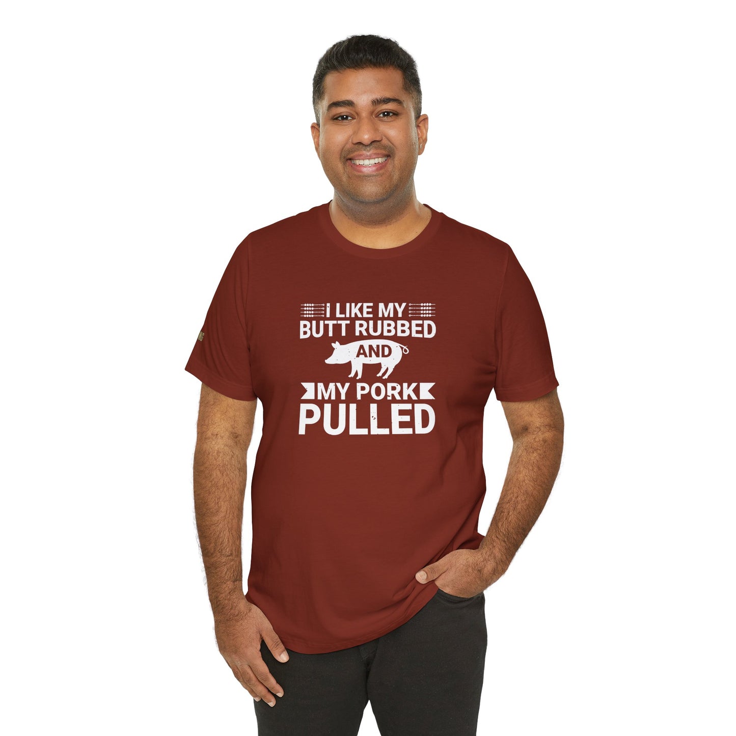 BBQ-themed t-shirt design with the phrase "I Like My Butt Rubbed & My Pork Pulled" featuring a pig silhouette and grilling utensils.