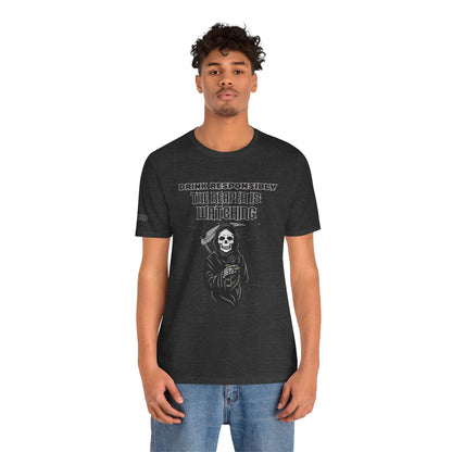 Grim Reaper beer shirt with funny dark humor alcohol quote “Drink Responsibly… The Reaper is Watching” design. In dark heather grey and plus sizes.