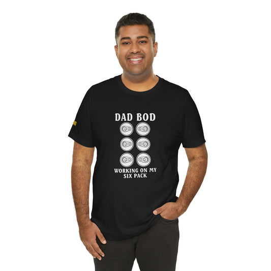 A model wearing the "Dad Bod – Working on My Six Pack" t-shirt, available in multiple colors and plus sizes, perfect for beer lovers and BBQ dads.
