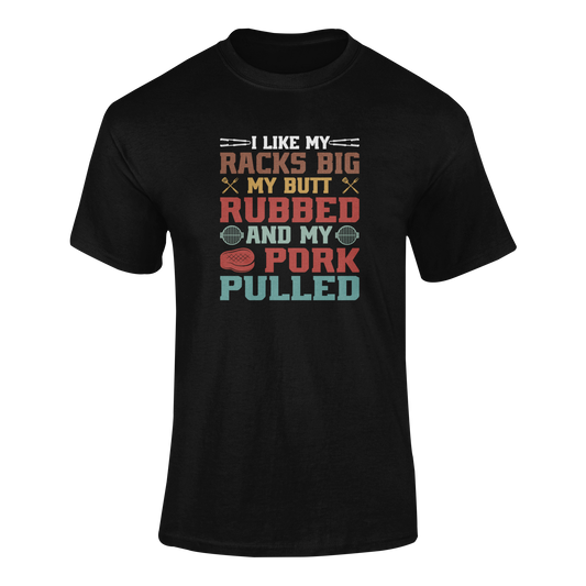 A funny BBQ-themed t-shirt with the phrase "I Like My Racks Big, My Butt Rubbed, and My Pork Pulled," featuring grilling utensils, a steak, and BBQ grill elements. Perfect for grill masters, BBQ lovers, and beer-drinking pitmasters.