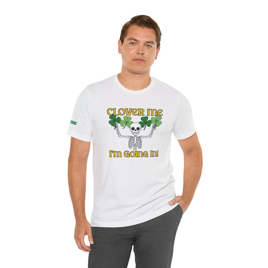 St. Patrick’s Day t-shirt featuring a skeleton with raised arms holding four-leaf clovers, paired with the phrase “Clover Me, I’m Going In!” in bold gold font on a black background.