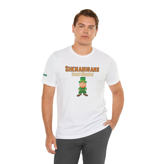 Funny St. Patrick’s Day t-shirt featuring a cartoon leprechaun with a tough-guy stance and bold text that reads “Shenanigans Coordinator.” A funny Irish drinking tee for party organizers and pub crawl champions.