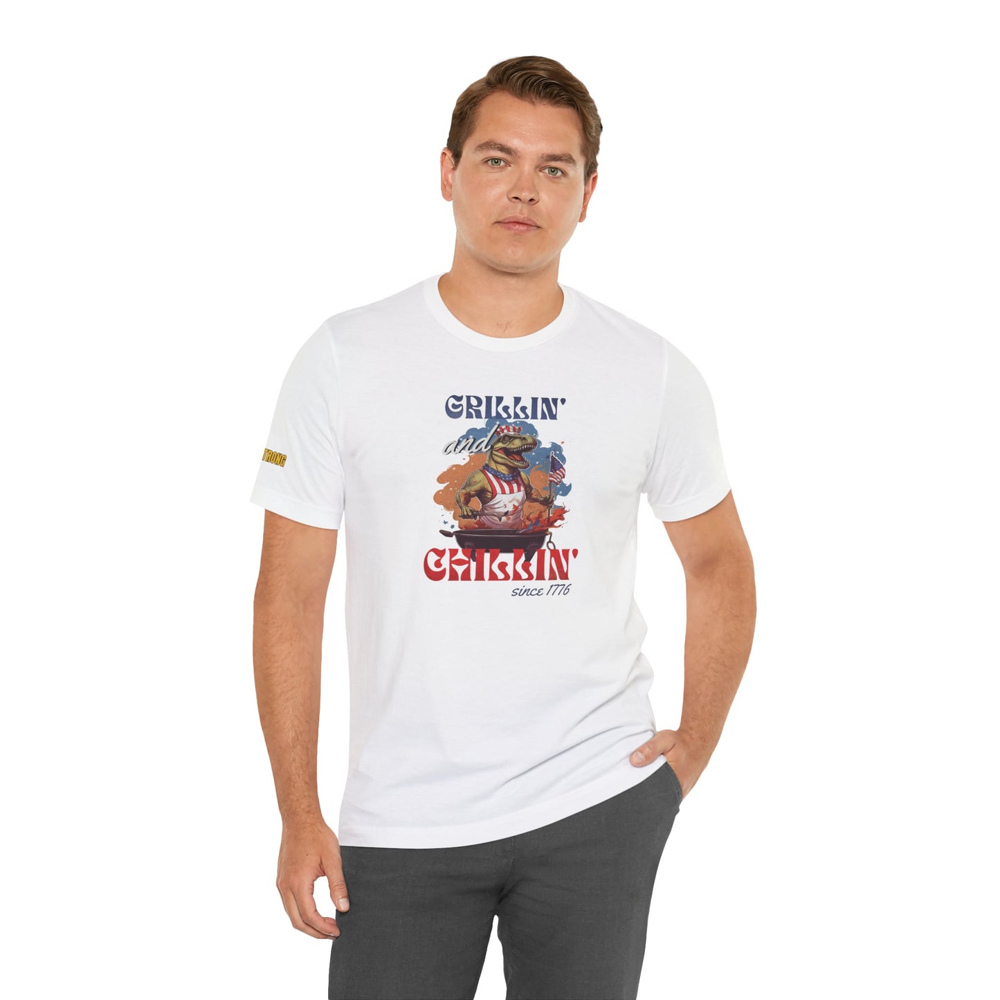 Funny 4th of July BBQ t-shirt featuring a patriotic T-Rex grilling in a red, white, and blue apron, waving an American flag. Perfect for beer and BBQ lovers. In white.