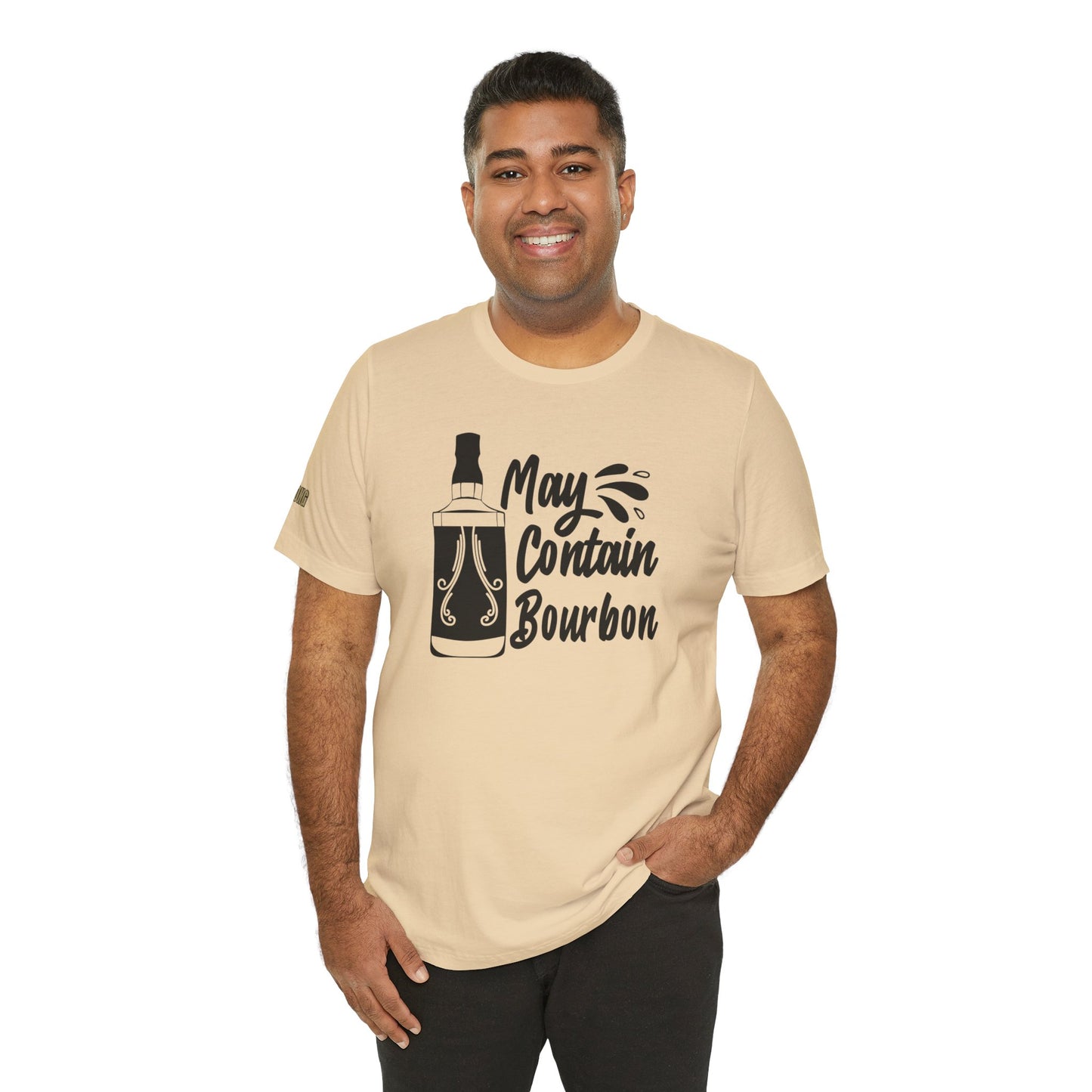 May Contain Bourbon humorous bourbon drinking graphic t-shirt featuring whiskey bottle and splash design shown in shade of beige. Available in many colors and plus sizes.